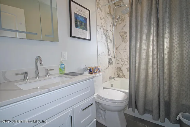 a bathroom with a sink a toilet and shower curtain