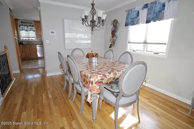 a dining room with furniture a chandelier and wooden floor
