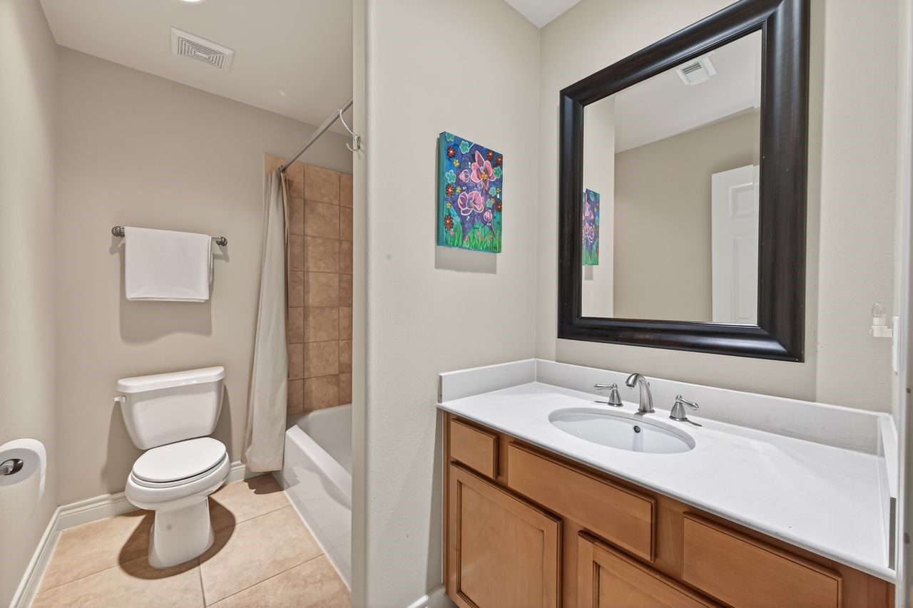 10932 Lasso Lane Houston, TX 77079 - Photo 29 of 38 a bathroom with a toilet sink and mirror