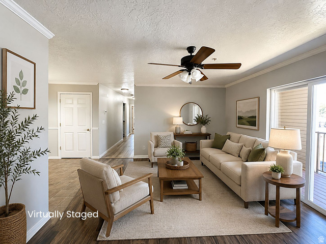 Spacious living area featuring wood-finish flooring, crown molding, and a ceiling fan with light fixture