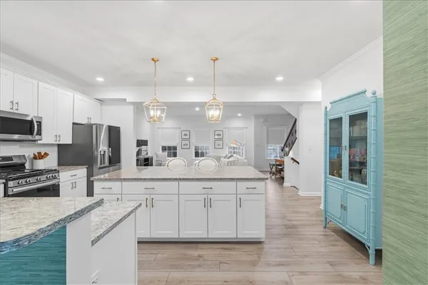 a kitchen with stainless steel appliances granite countertop a sink a stove and a wooden floors