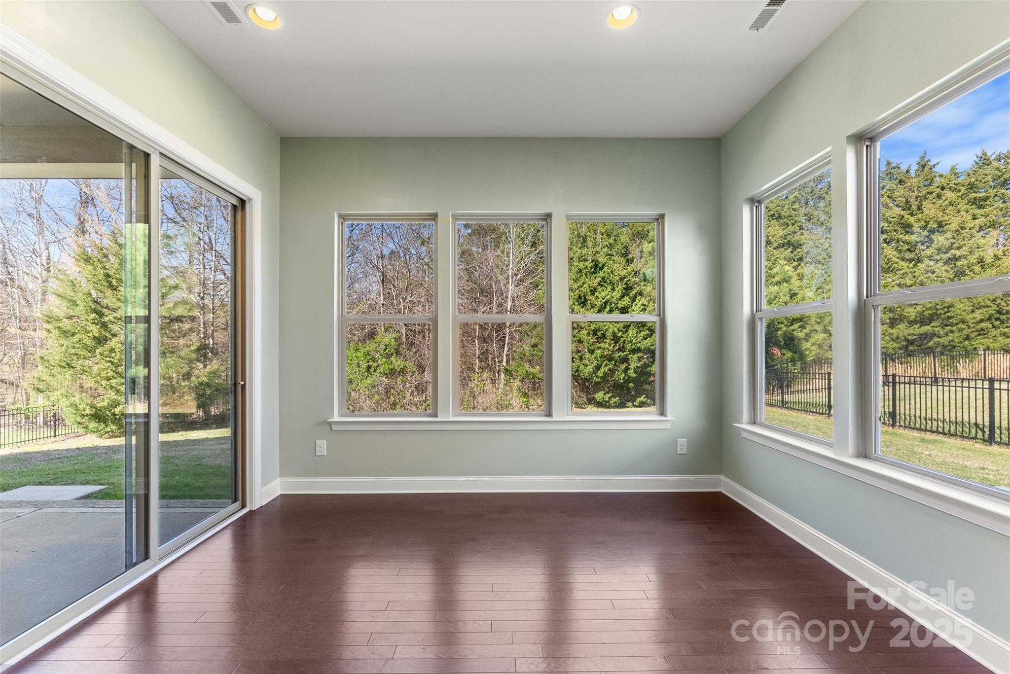 11037 Thornbeck Lane Midland, NC 28107 - Photo 22 of 46 a view of an empty room with wooden floor and a floor to ceiling window