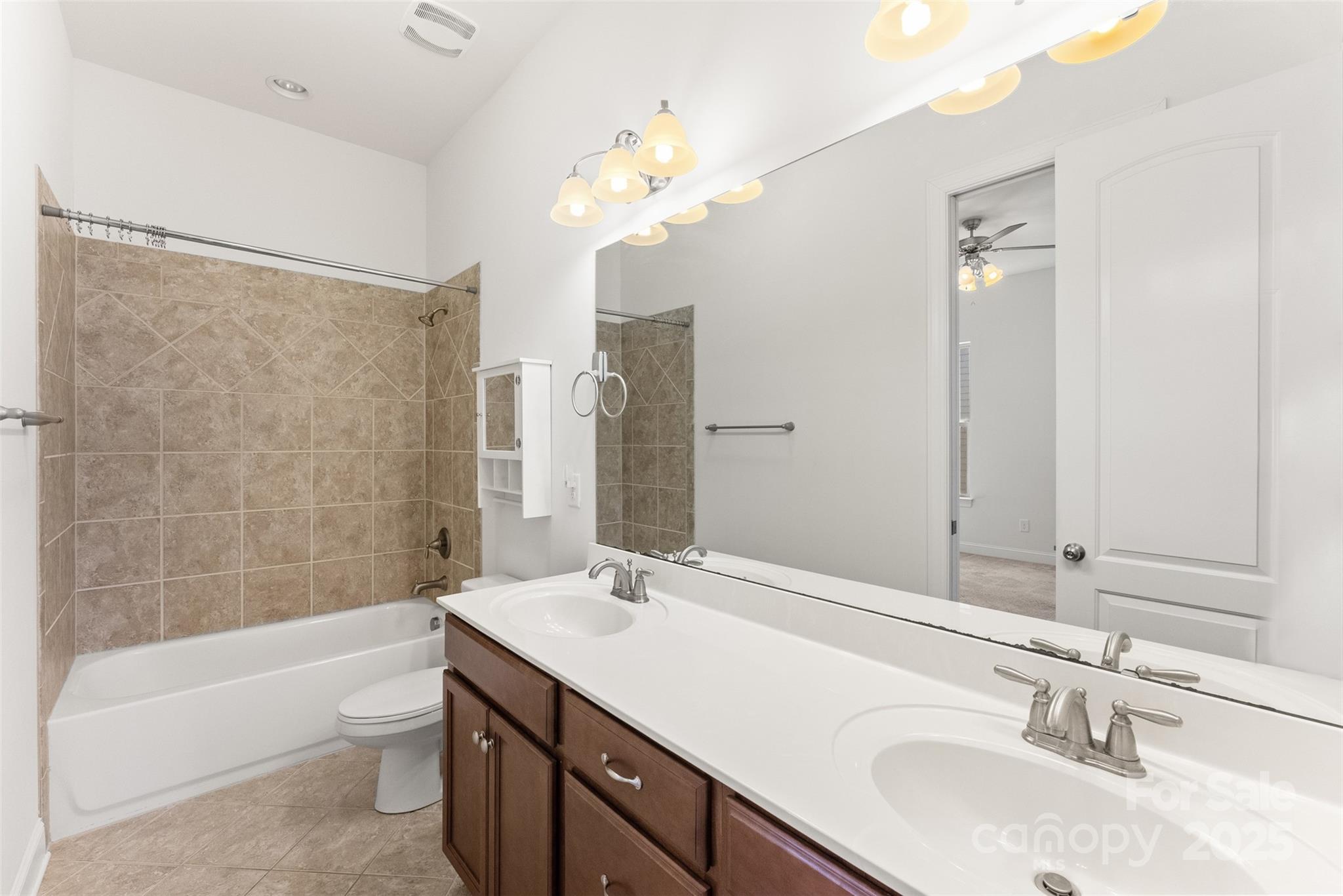 11037 Thornbeck Lane Midland, NC 28107 - Photo 27 of 46 a bathroom with a granite countertop sink a toilet a mirror a bathtub and shower