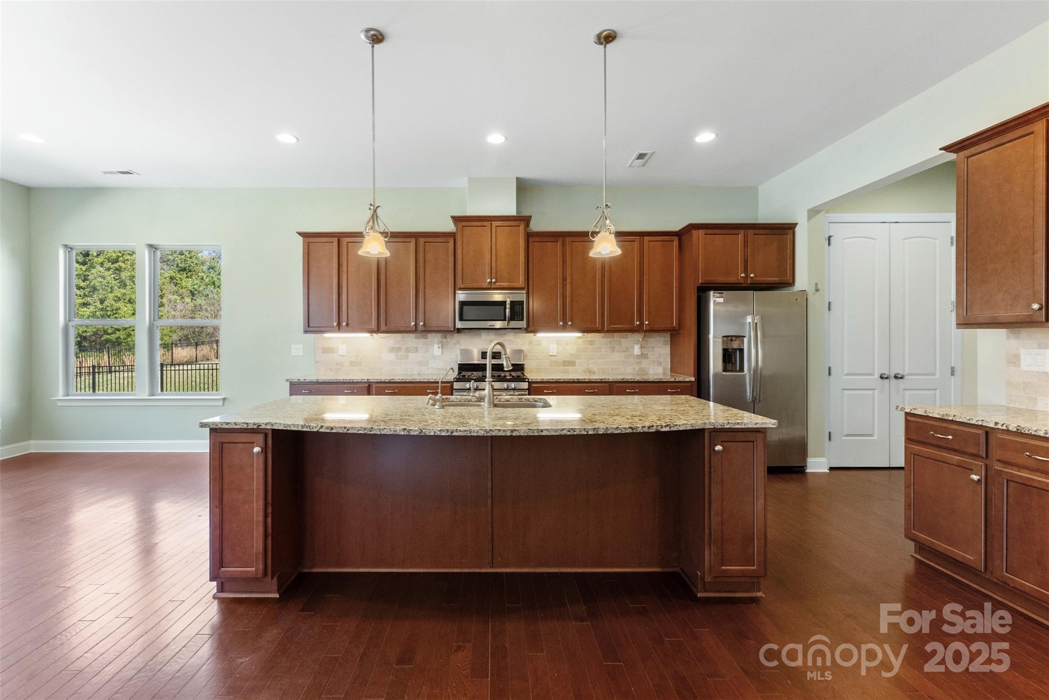 11037 Thornbeck Lane Midland, NC 28107 - Photo 4 of 46 a kitchen with kitchen island granite countertop wooden floors and wide window