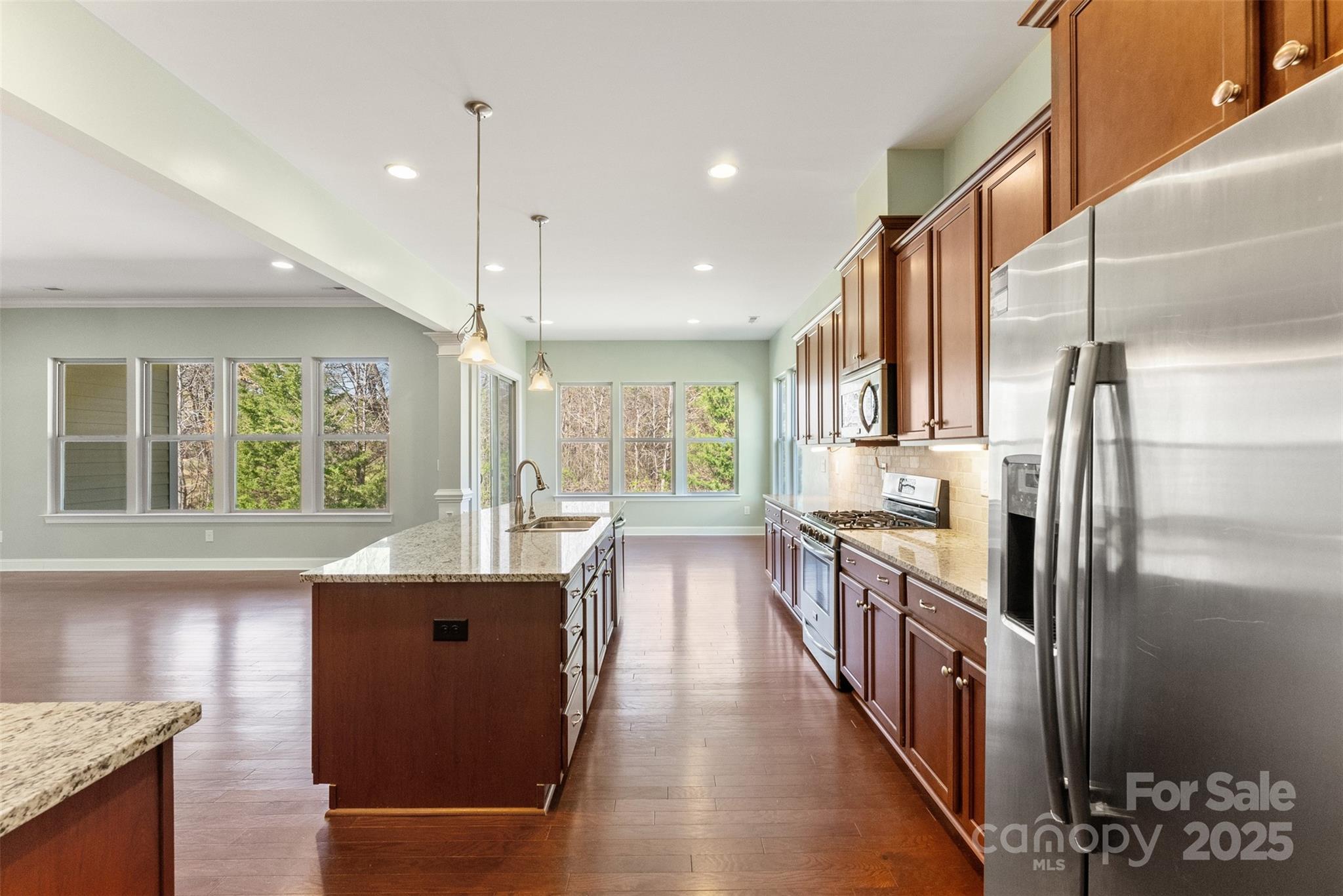 11037 Thornbeck Lane Midland, NC 28107 - Photo 9 of 46 a kitchen with stainless steel appliances granite countertop a refrigerator a sink dishwasher a stove and a dining table with wooden floor