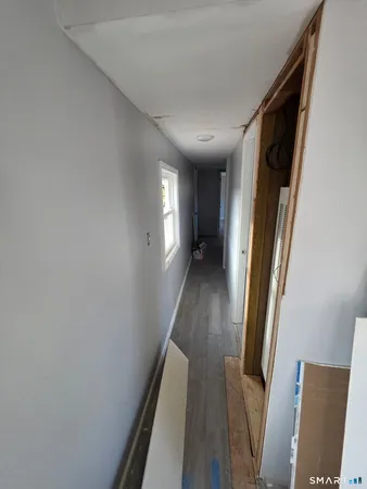a view of a hallway with wooden floor and staircase