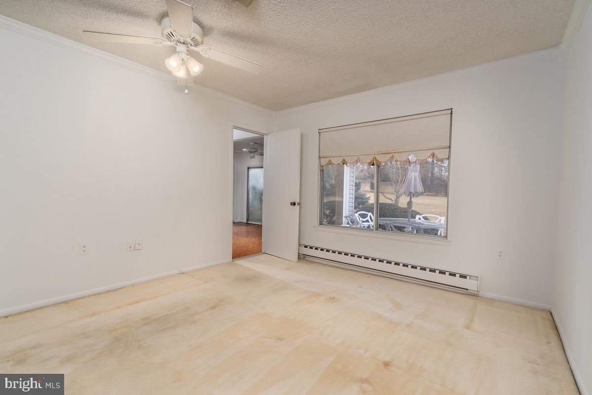 3507 Tarkington Lane, Unit 66A Silver Spring, MD 20906 - Photo 12 of 39 an empty room with a fireplace and chandelier