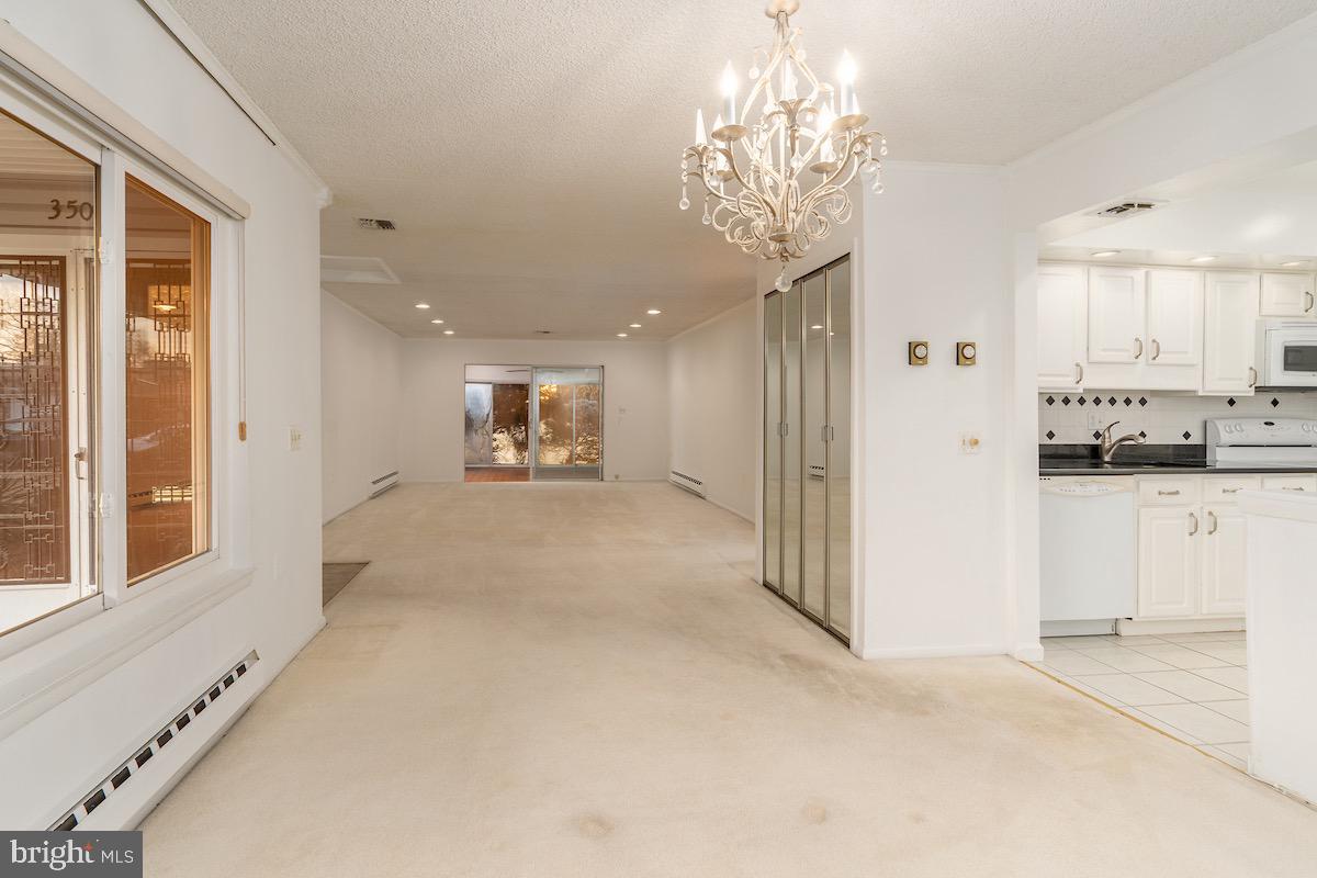 3507 Tarkington Lane, Unit 66A Silver Spring, MD 20906 - Photo 31 of 39 a view of a hallway with kitchen and chandelier