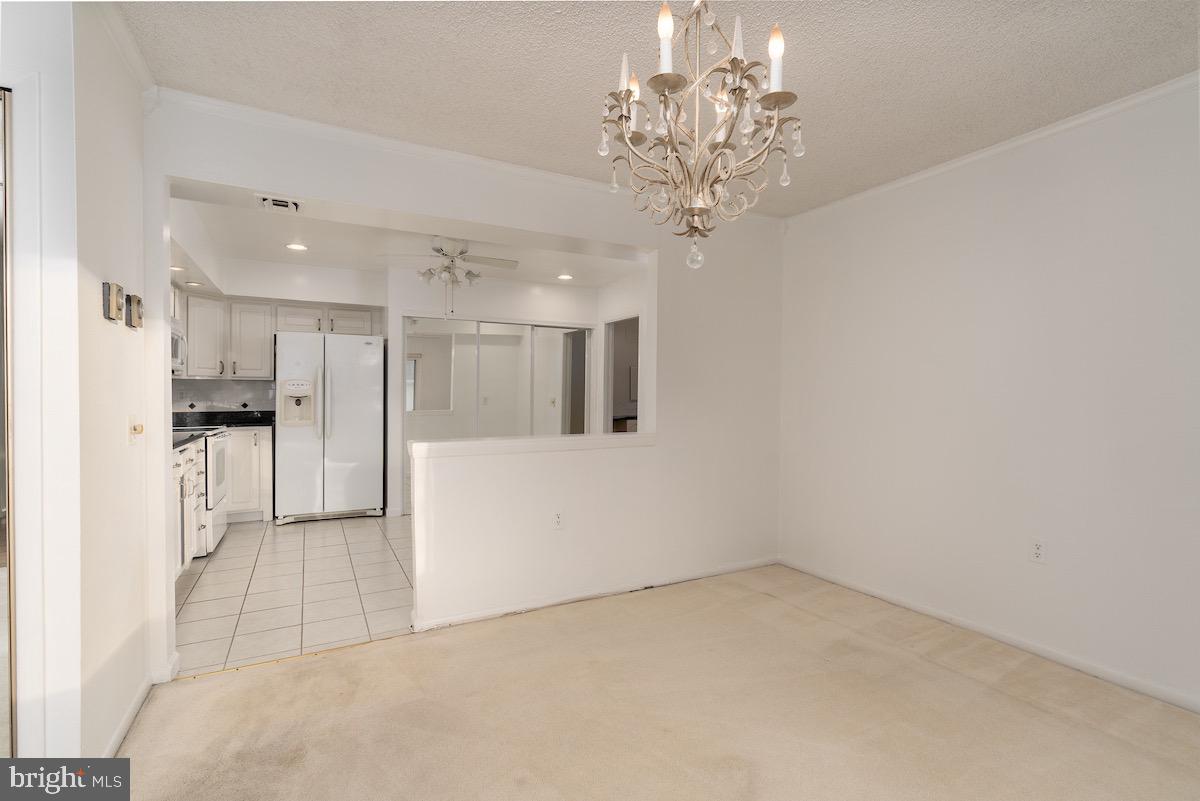 3507 Tarkington Lane, Unit 66A Silver Spring, MD 20906 - Photo 32 of 39 a view of a kitchen with a refrigerator a kitchen island wooden floor and a chandelier