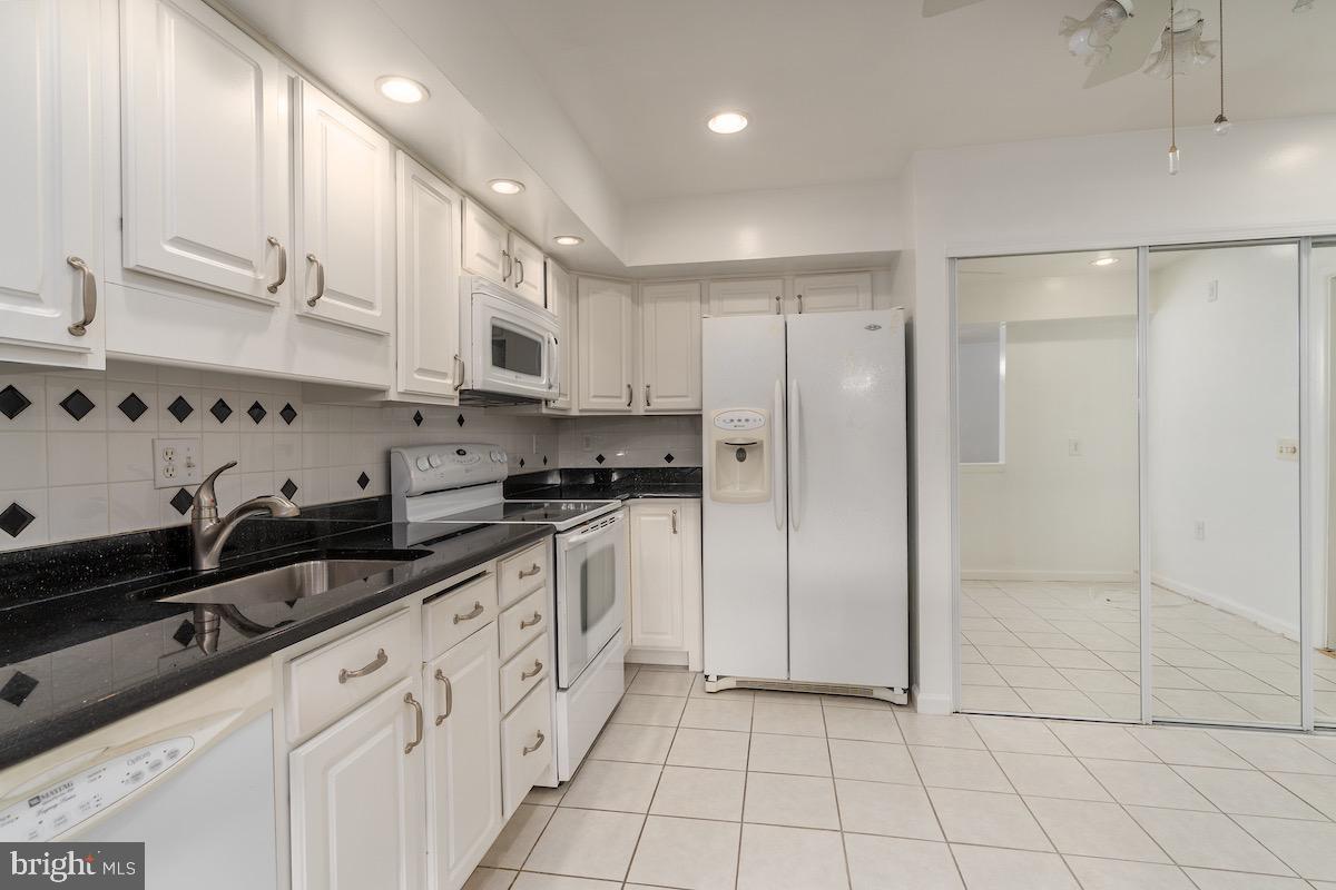 3507 Tarkington Lane, Unit 66A Silver Spring, MD 20906 - Photo 33 of 39 a kitchen with granite countertop white cabinets and stainless steel appliances