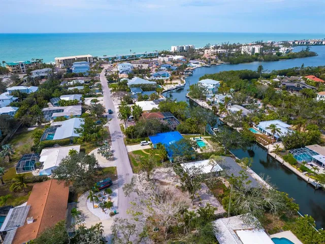 an aerial view of a city with lots of residential buildings ocean and mountain view in back