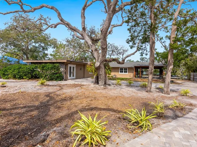 a front view of a house with a tree