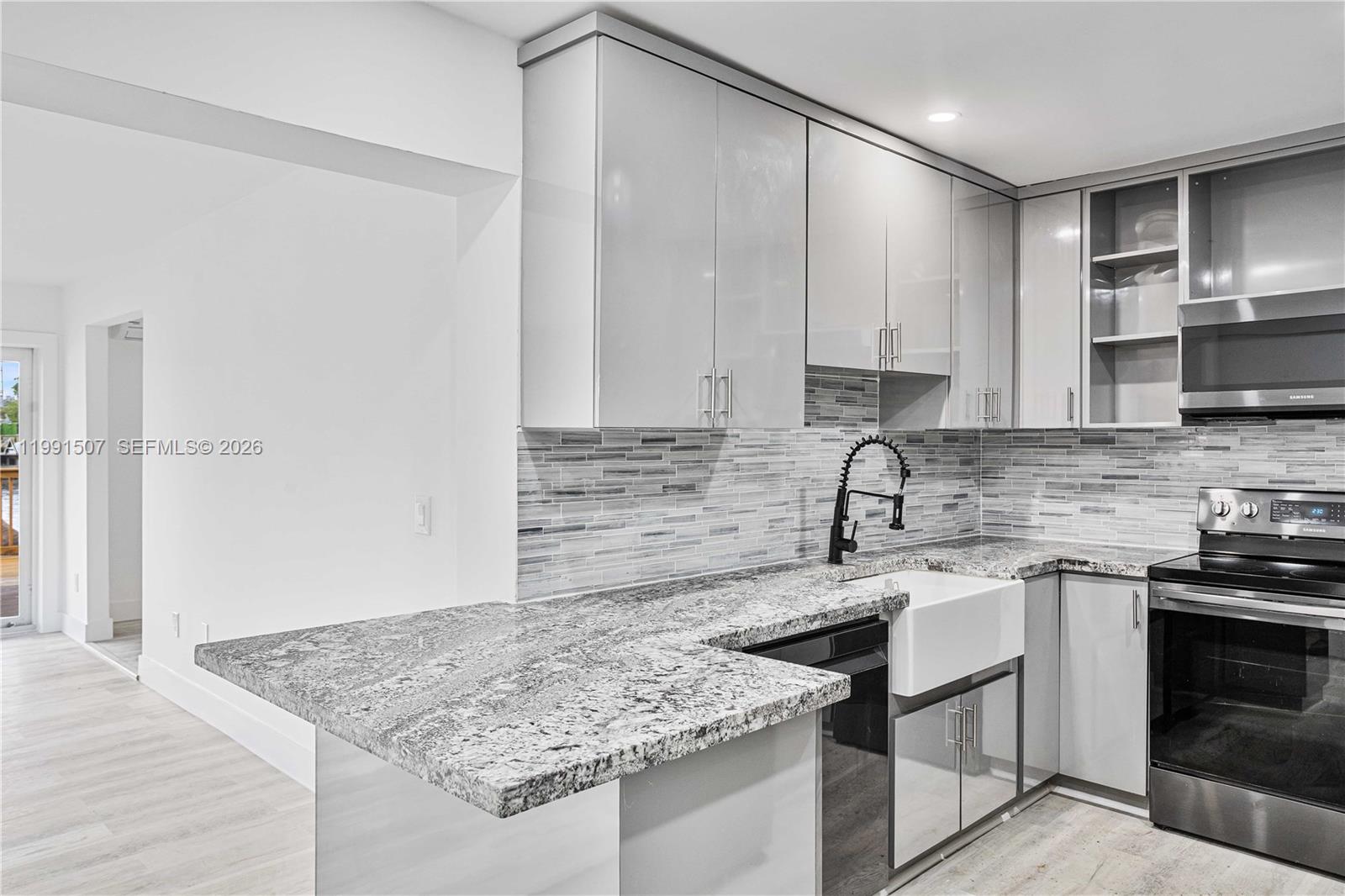 4157 Southwest 49th Court Dania Beach, FL 33314 - Photo 13 of 46 a kitchen with stainless steel appliances granite countertop a sink stove and cabinets