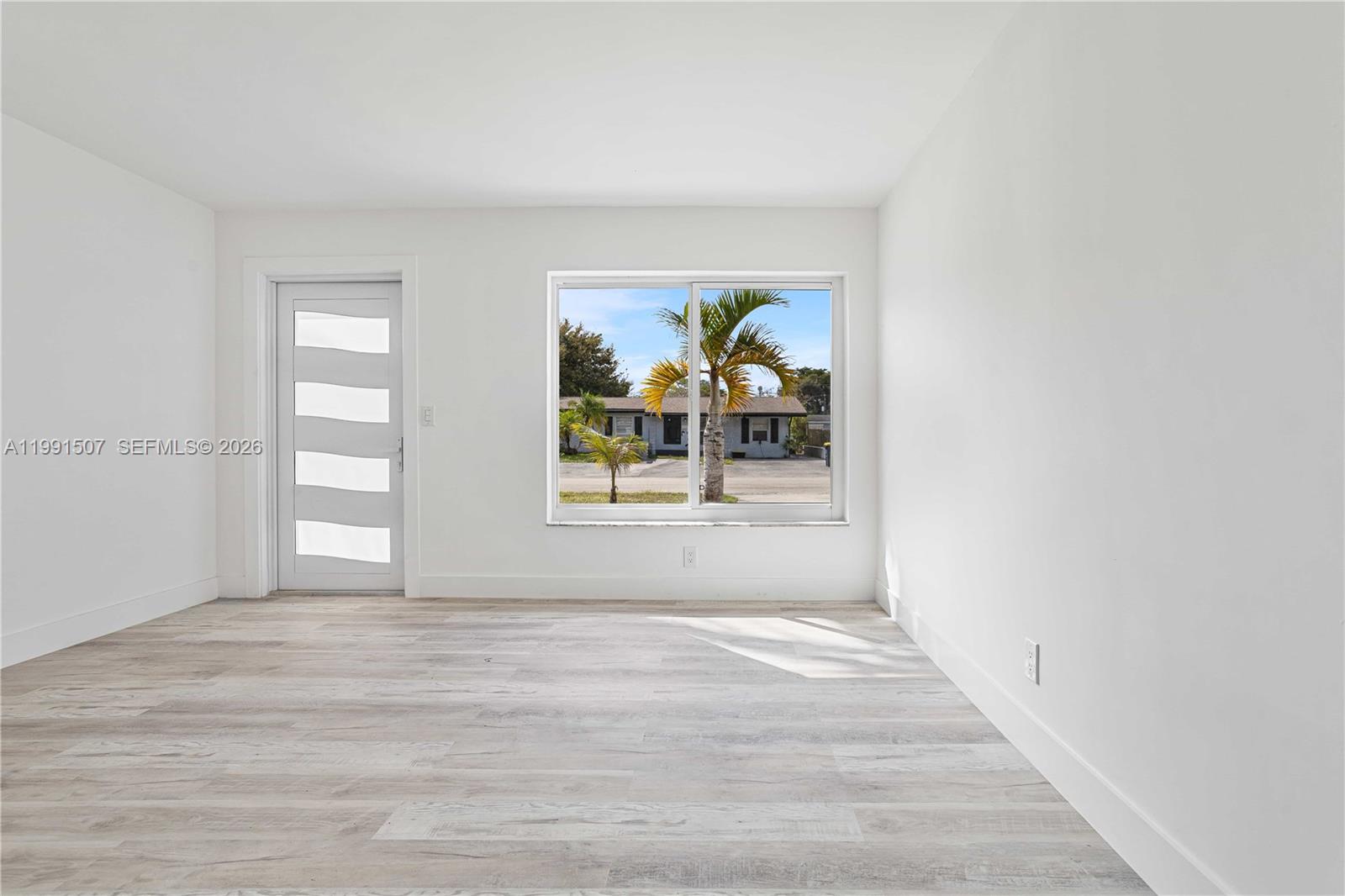 4157 Southwest 49th Court Dania Beach, FL 33314 - Photo 15 of 46 a view of an empty room with window and wooden floor
