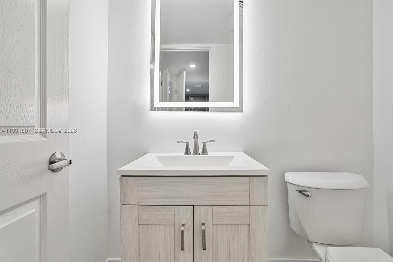4157 Southwest 49th Court Dania Beach, FL 33314 - Photo 32 of 46 a bathroom with a toilet sink and mirror