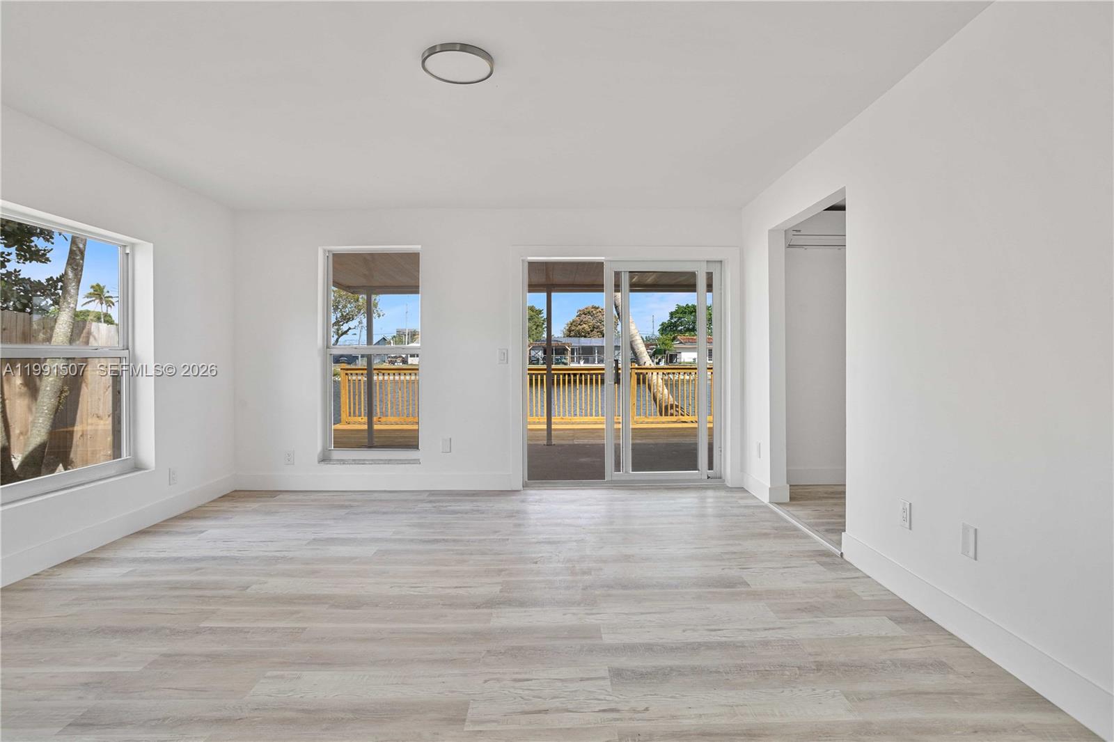 4157 Southwest 49th Court Dania Beach, FL 33314 - Photo 6 of 46 a view of an empty room with a window and wooden floor