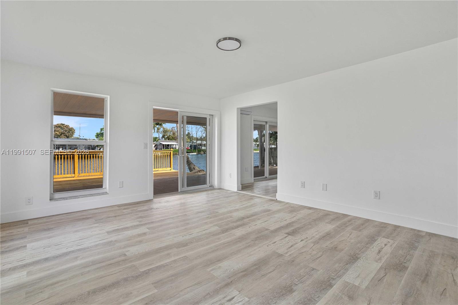 4157 Southwest 49th Court Dania Beach, FL 33314 - Photo 8 of 46 a view of an empty room with a window and wooden floor