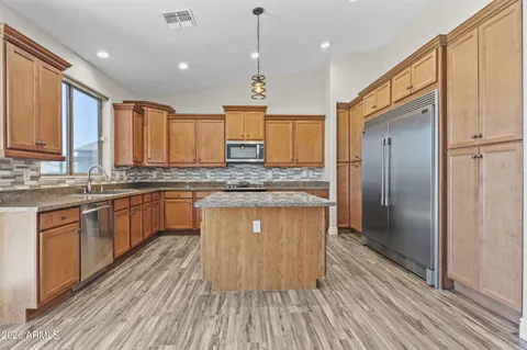 a kitchen with kitchen island granite countertop wooden floors granite counter tops and a window