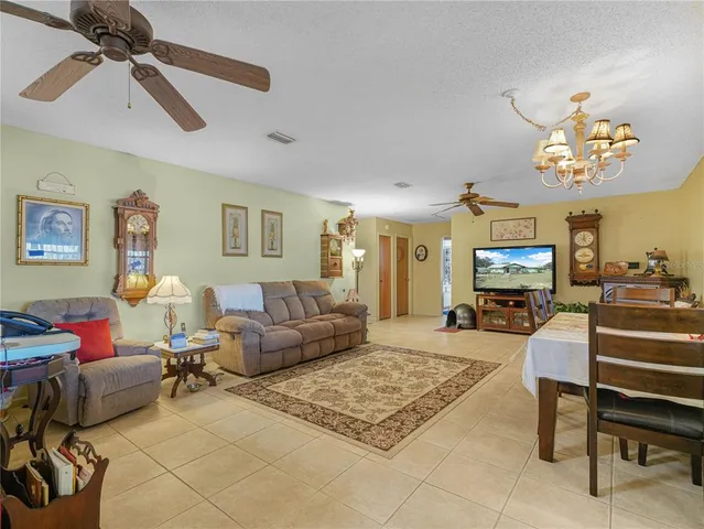 a living room with furniture a chandelier and a flat screen tv