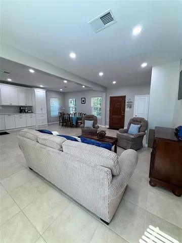 a living room with furniture kitchen and a chandelier
