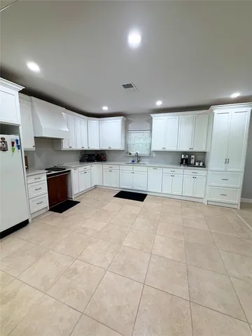 a large kitchen with cabinets and a window