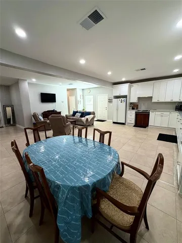 a dining table with chairs and kitchen view
