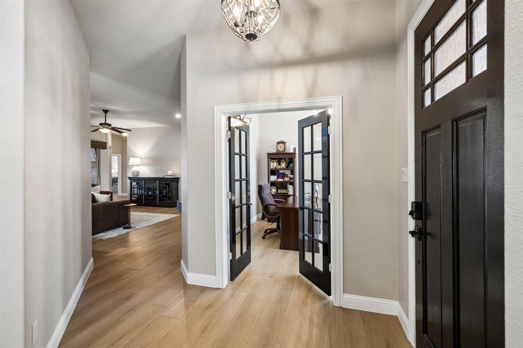 3917 Gatewick Drive Rockwall, TX 75087 - Photo 5 of 34 a view of a hallway with wooden floor and a living room