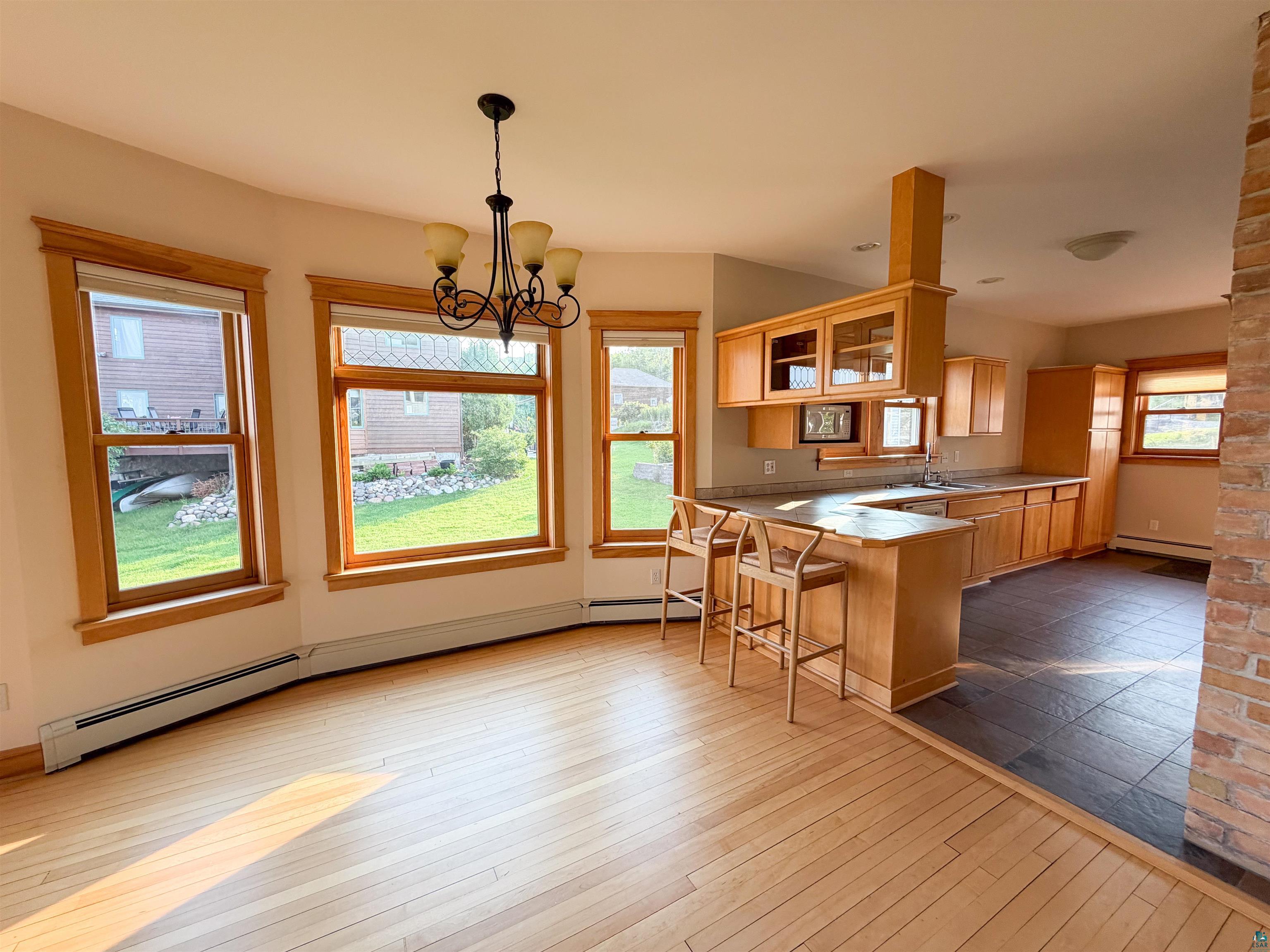 13 West 8th Street Duluth, MN 55806 - Photo 7 of 57 Bright dining area featuring hardwood flooring, a multi-light chandelier, and three bay windows with wood trim