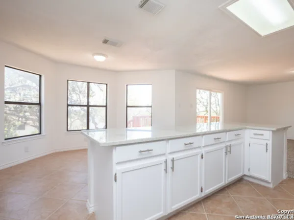 an empty room with windows and dual sinks