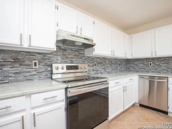 a kitchen with white cabinets and white appliances