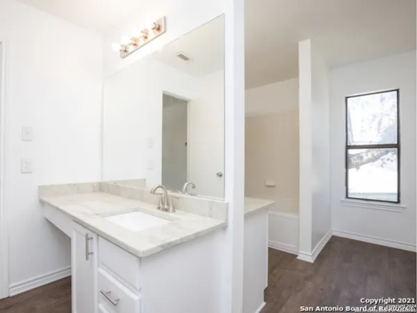 a bathroom with a granite countertop sink and a mirror