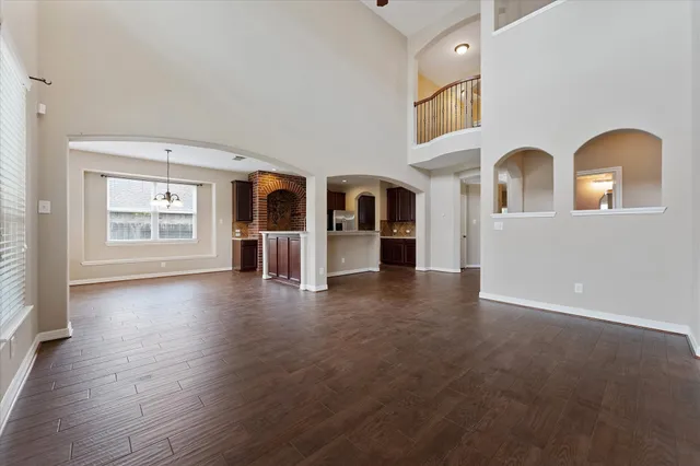 a view of a hallway with wooden floor and a chandelier