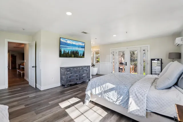 a spacious bedroom with a bed and wooden floor