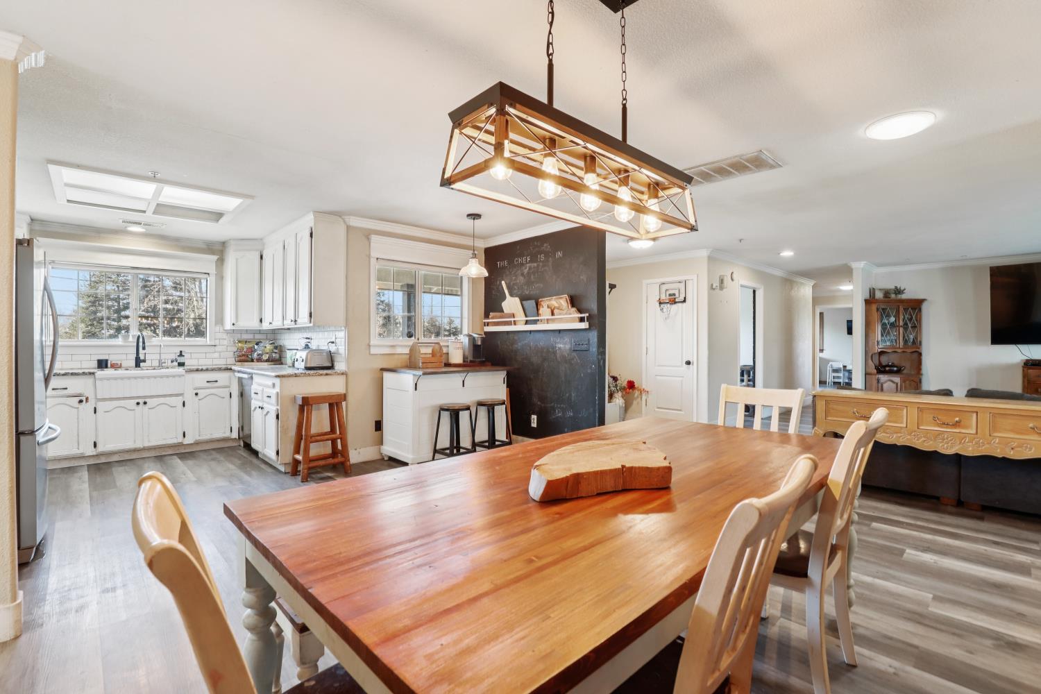 11213 Colony Road Wilton, CA 95693 - Photo 7 of 48 a kitchen with stainless steel appliances kitchen island granite countertop a dining table chairs and white cabinets