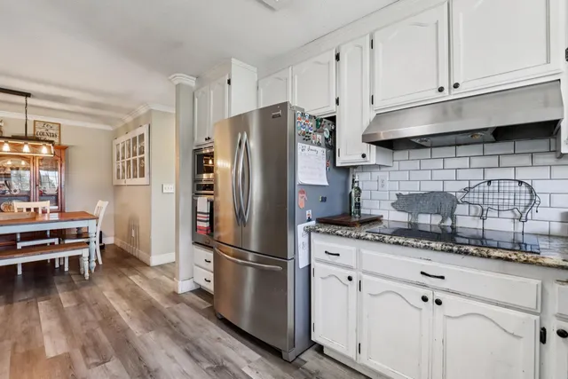 a kitchen with appliances a refrigerator and cabinets