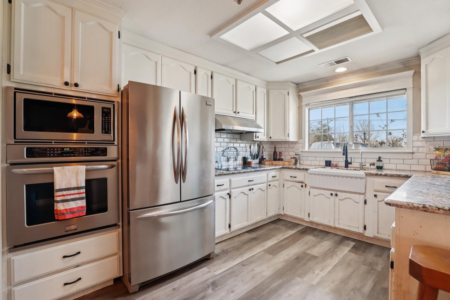 11213 Colony Road Wilton, CA 95693 - Photo 9 of 48 a kitchen with granite countertop white cabinets and stainless steel appliances