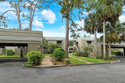 front view of a house with a yard and palm trees
