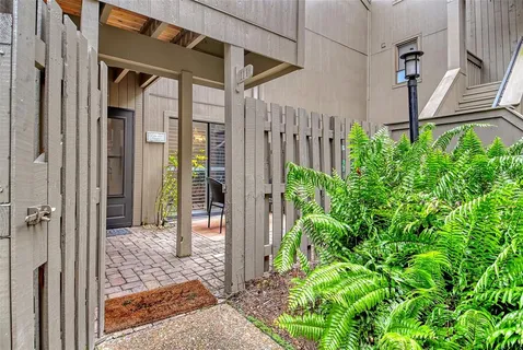 a backyard of a house with outdoor seating and plants