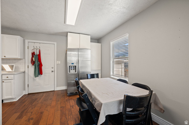 594 850 West Provo, UT 84601 - Photo 7 of 33 Kitchen space featuring wood-finish flooring, white cabinetry, a subway tile backsplash, and a stainless steel refrigerator