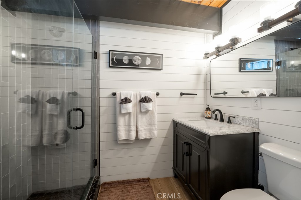 1107 Cedar Mountain Road Big Bear City, CA 92314 - Photo 33 of 42 a bathroom with a granite countertop sink a toilet and shower