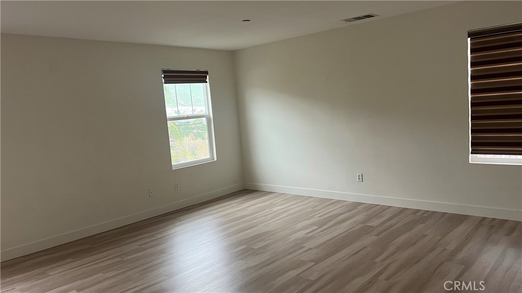 20349 Barrel Road Riverside, CA 92507 - Photo 4 of 21 an empty room with wooden floor and windows