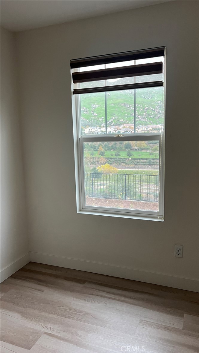 20349 Barrel Road Riverside, CA 92507 - Photo 5 of 21 a view of an empty room with wooden floor and a window