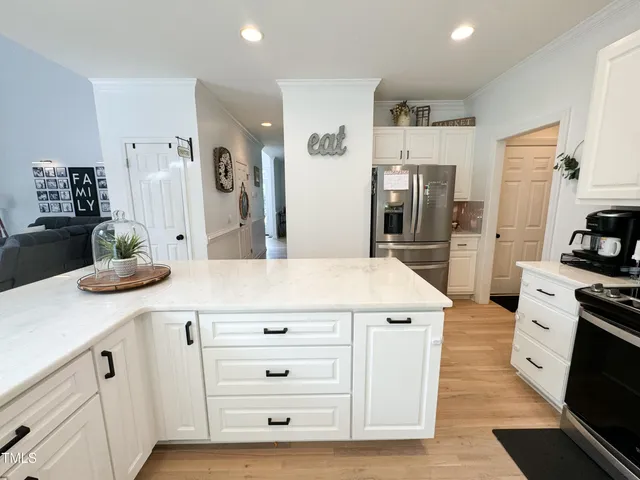 a kitchen with white cabinets and appliances