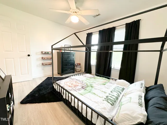 a bedroom with a bed window and a chandelier