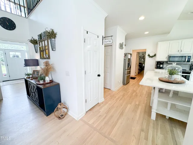 a kitchen with stainless steel appliances kitchen island granite countertop a refrigerator a stove and a wooden floors