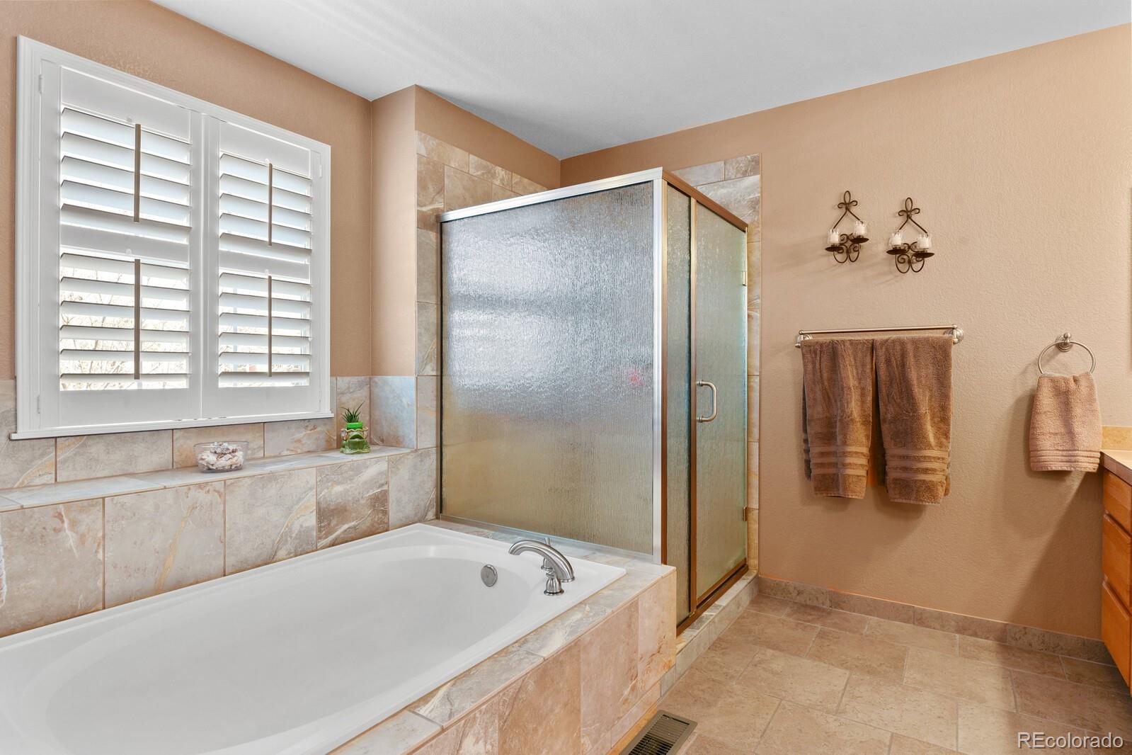 10144 Spring Water Court Highlands Ranch, CO 80129 - Photo 17 of 40 a bathroom with a tub a window and a shower