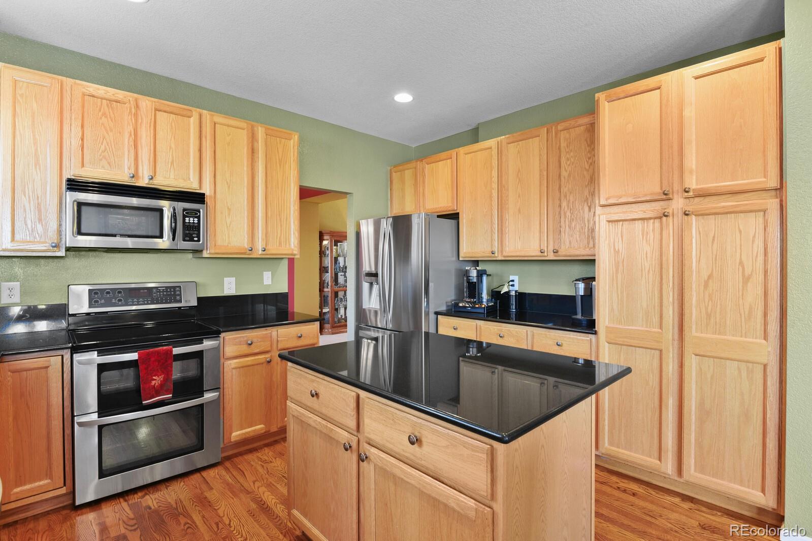 10144 Spring Water Court Highlands Ranch, CO 80129 - Photo 6 of 40 a kitchen with stainless steel appliances granite countertop a refrigerator sink and stove