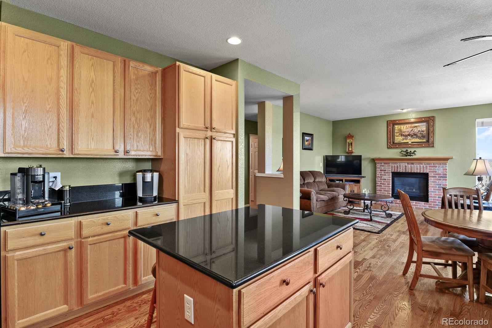 10144 Spring Water Court Highlands Ranch, CO 80129 - Photo 7 of 40 a kitchen with granite countertop a table chairs microwave and cabinets