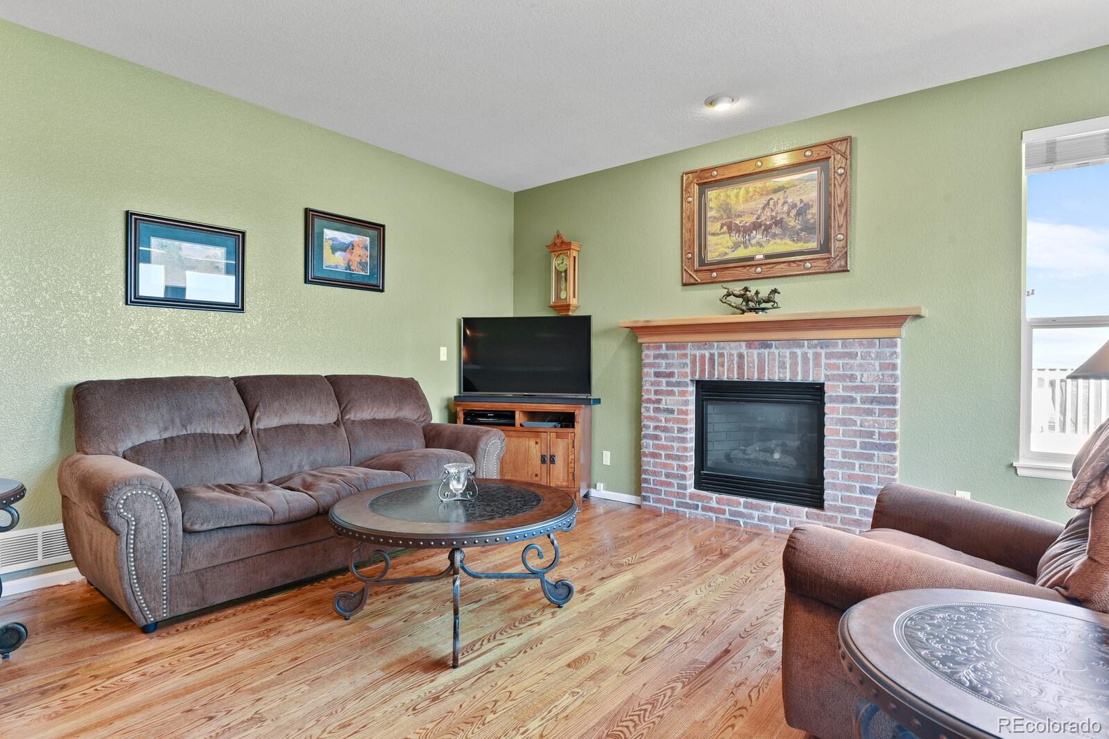 10144 Spring Water Court Highlands Ranch, CO 80129 - Photo 10 of 40 a living room with furniture a flat screen tv and a fireplace