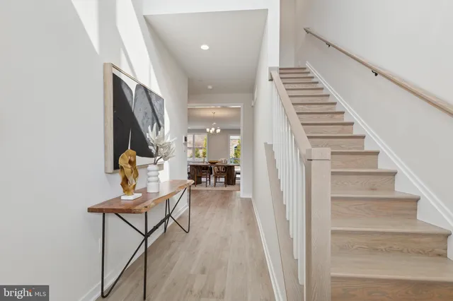 a view of a hallway with wooden floor and stairs